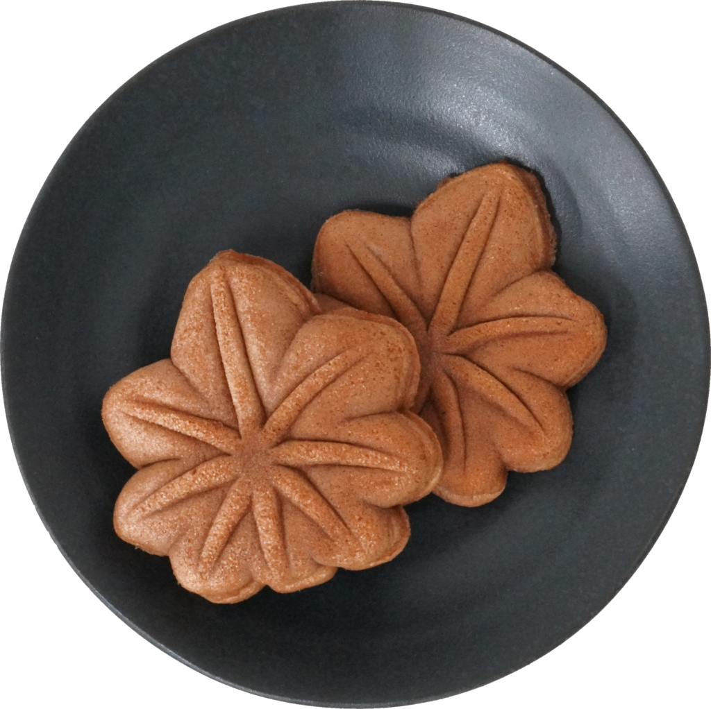 紅葉饅頭の画像。黒い皿に二つ置かれている